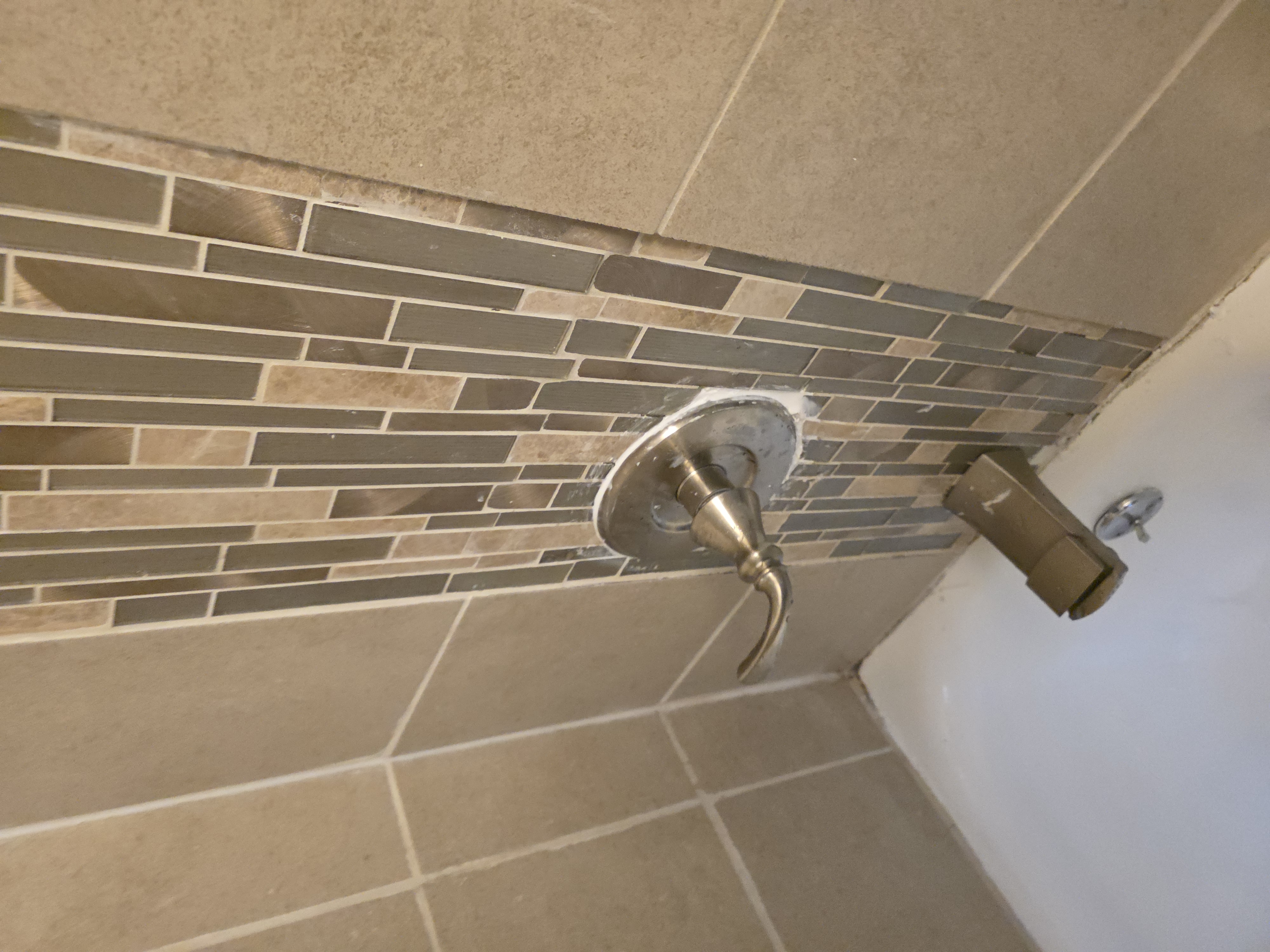 Shower handle secured and caulked after repair